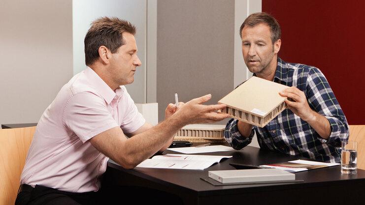 Detailberatung zu verschiedenen Holzmaterialien -und dichten zwischen zwei Männern