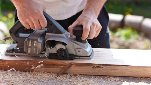 Mann mit Elektrohobel Seitenansicht Querformat