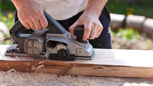 Mann mit Elektrohobel Seitenansicht Querformat