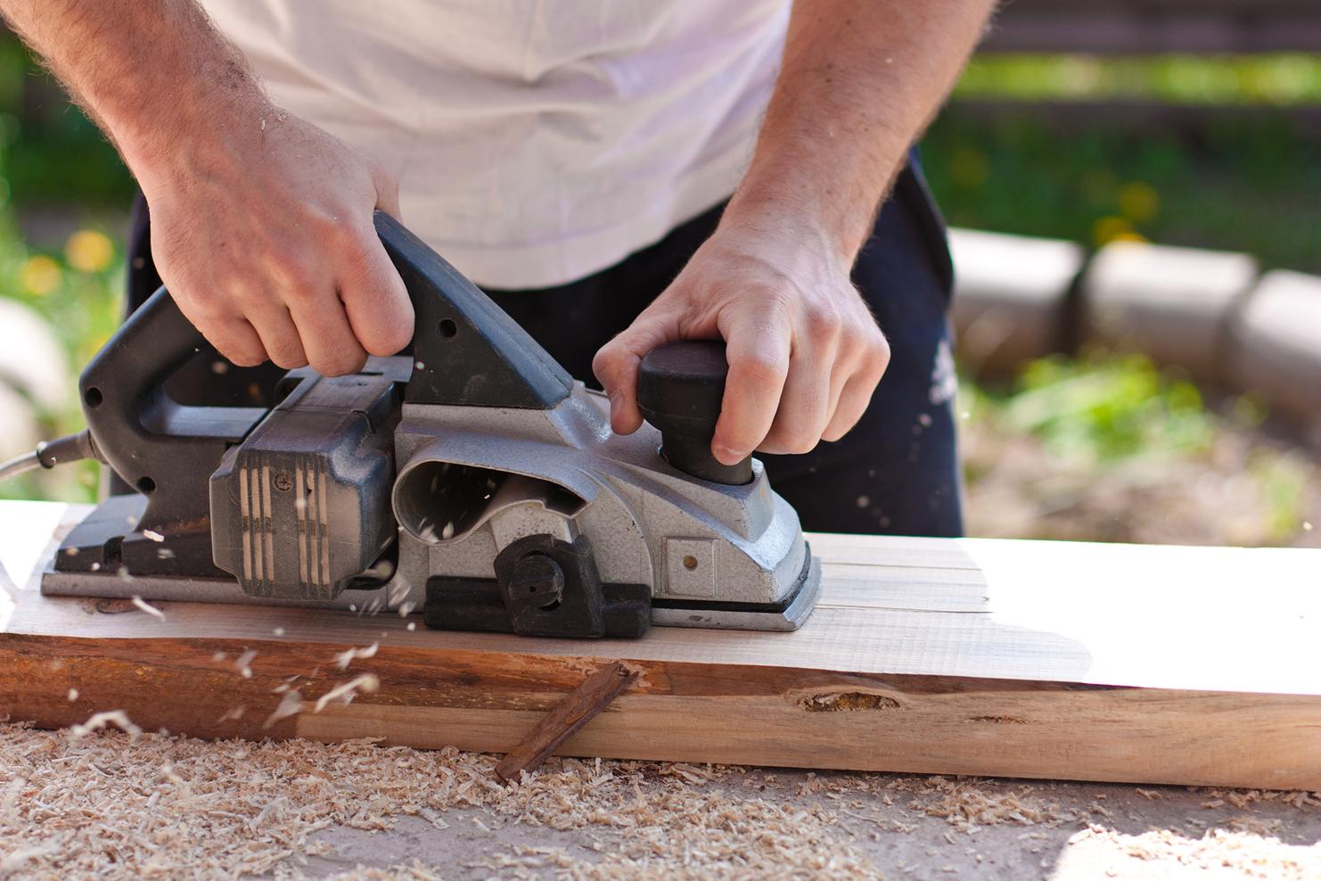 Mann mit Elektrohobel Seitenansicht Querformat